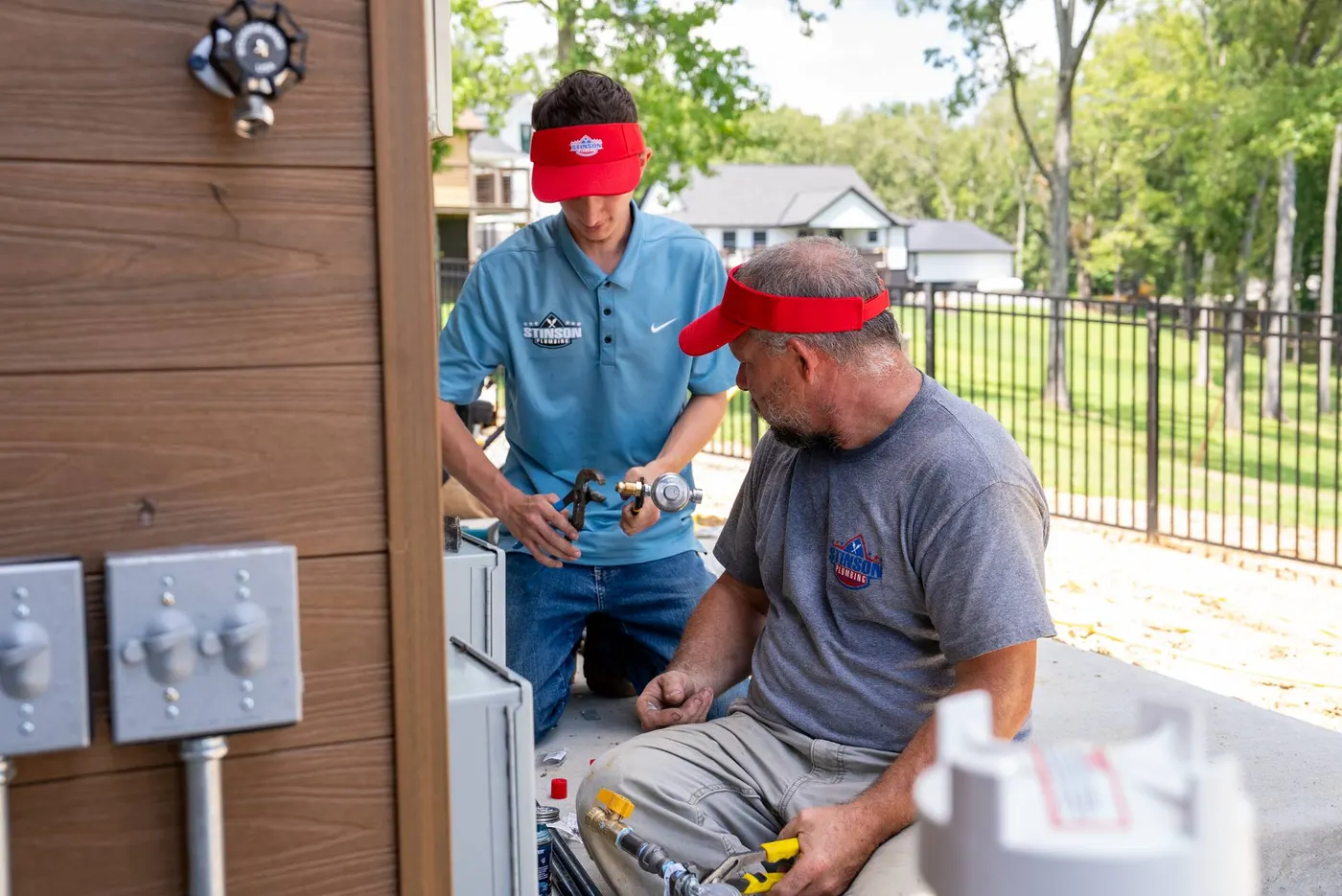 Two Stinson techs fitting a gas connection outdoors